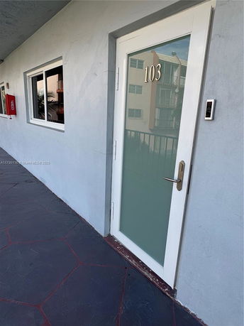 View of a building entrance with a door labeled 103.