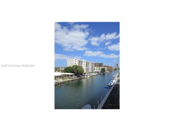 View of a canal with several mid-rise buildings lining the waterway, and boats docked along the side.
