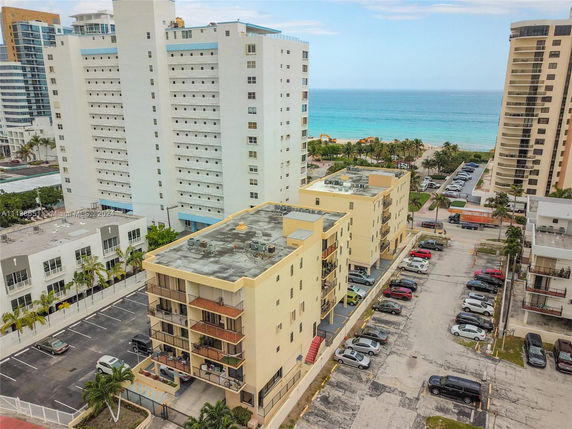 View of multiple residential buildings with the ocean in the background.