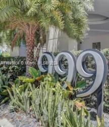 Front area of a building with large numeric address signage and landscaping.