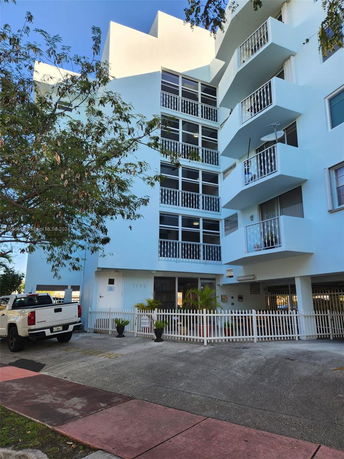 Front view of a multi-story residential building with balconies.