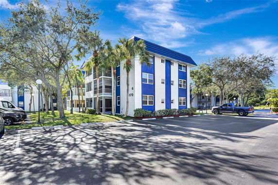 Front view of a multi-story building with blue and white facade.