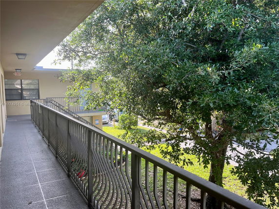 Exterior walkway of a building with a metal railing.