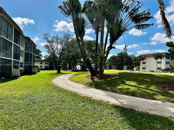 Residential buildings with a path and greenery in the surrounding area.