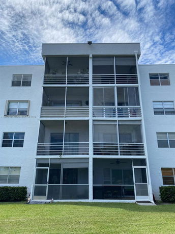 Front view of a multi-story building with balconies and screened porches.