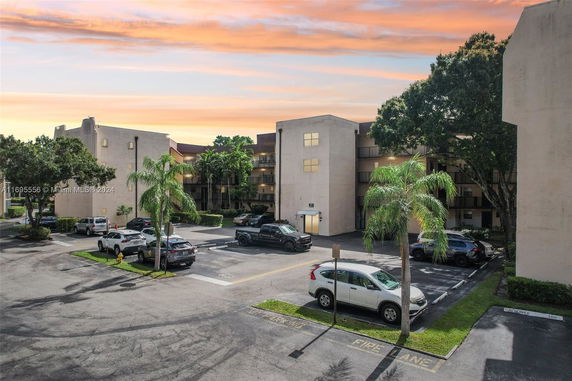 Outdoor parking area in front of a multi-story building.