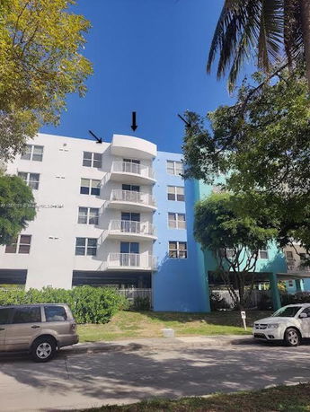 Front view of a multi-story apartment building with balconies.