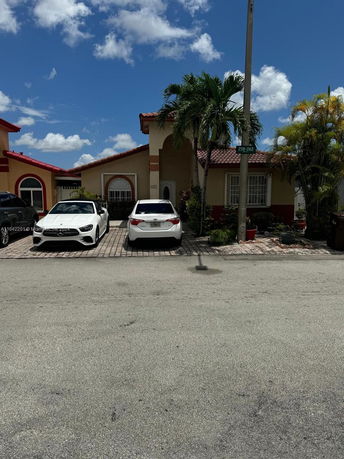 Front view of a single-story house with a tiled roof and driveway parking.