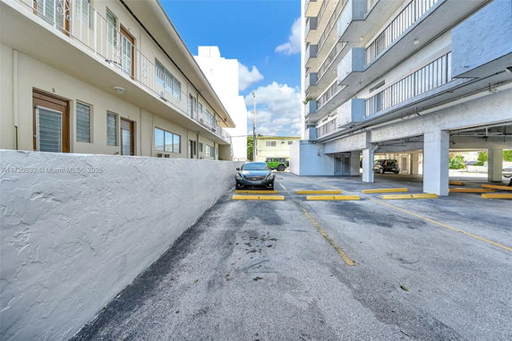 Outdoor parking area beside a multi-story building.
