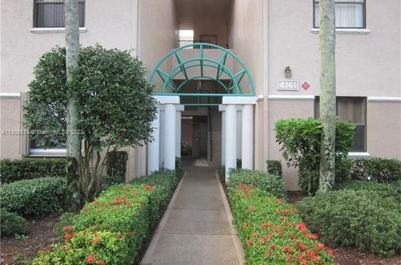 Front view of a building with an arched entrance and columns.