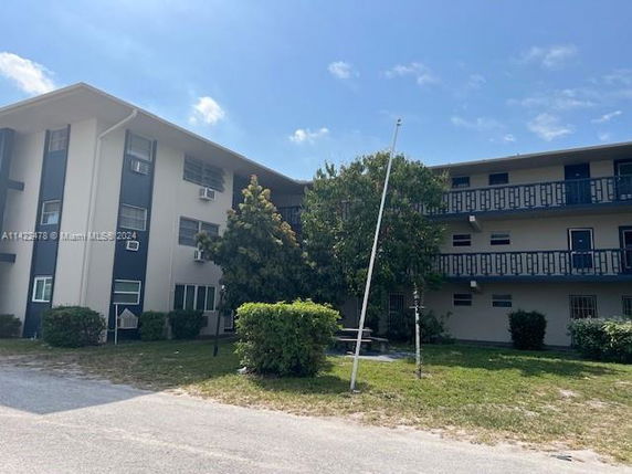 Front view of a three-story apartment building with balconies.