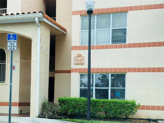 Front view of a multi-story building with a beige facade and orange accents.