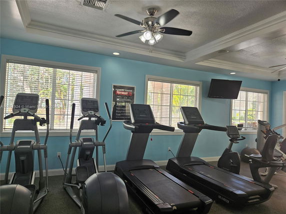 Indoor fitness room with exercise equipment, including treadmills and ellipticals.