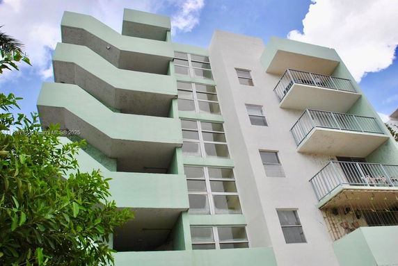Front view of a multi-story building with balconies.