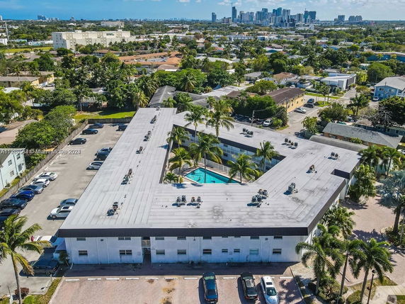 Aerial view of a building with a large rooftop with air conditioning units and other equipment.