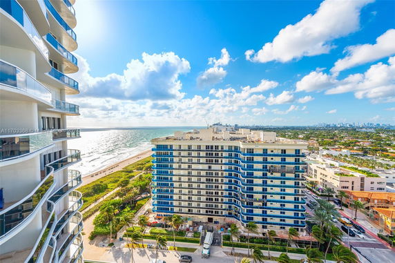 View from a high-rise building overlooking the ocean and city skyline.