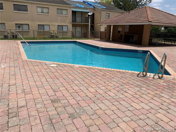 Outdoor swimming pool with adjacent building in the background.