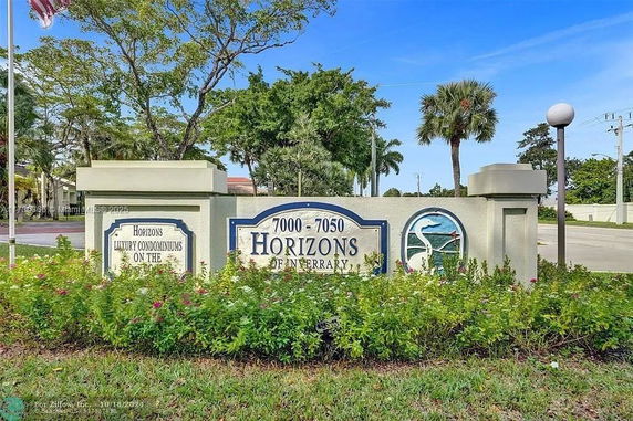 Signage for Horizons Luxury Condominiums with surrounding trees and road