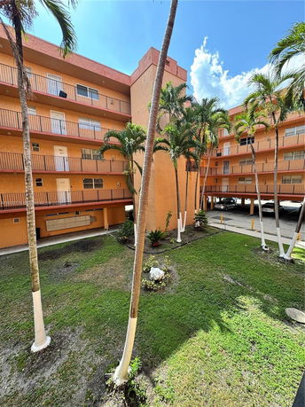 Front view of a multi-story apartment building with balconies.