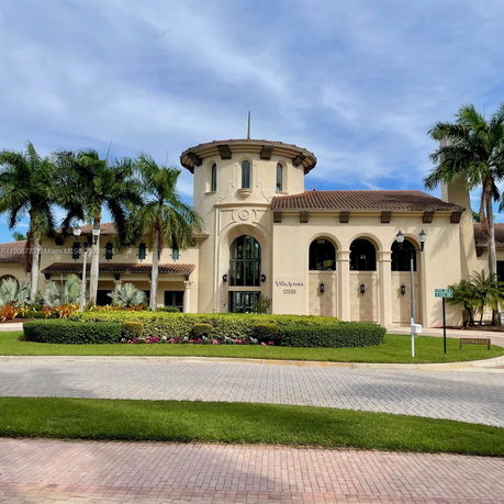 Front view of a building with a circular tower and arched windows.
