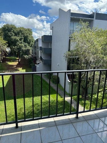 View from a balcony overlooking neighboring buildings and trees.