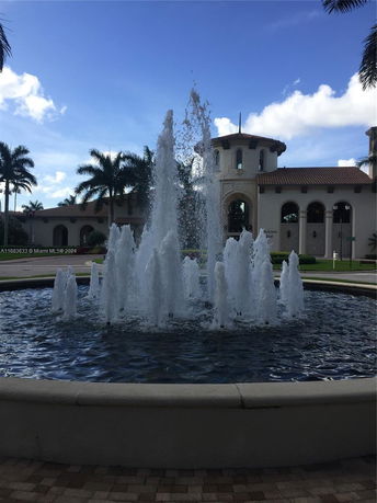 View of a building with a fountain in the foreground.