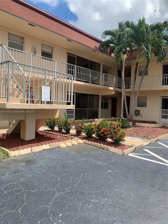 Front view of a two-story building with an external staircase and railing.