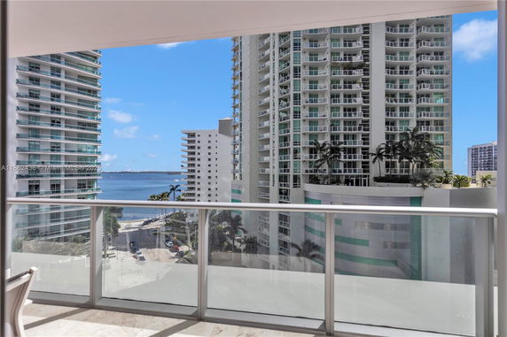 Panoramic view of high-rise buildings and water from a balcony.