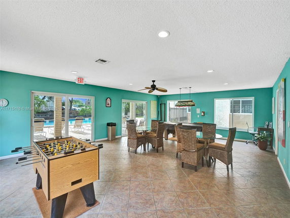 Indoor recreational area with foosball table, pool table, and seating.