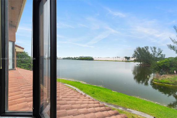 View from a window showing the water and greenery outside.