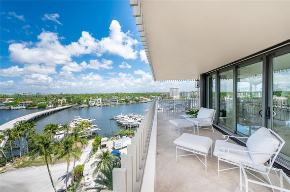 View from a balcony overlooking a river and a bridge with a scenic skyline in the background.