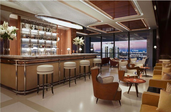 Elegant indoor lounge area with a bar and seating, featuring modern design and large windows.