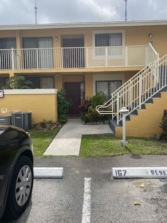 Front view of a two-story apartment building with external staircase.