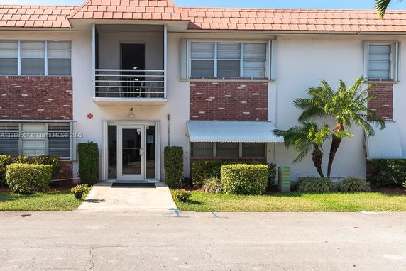 Front view of a two-story apartment building with a brick and stucco facade.
