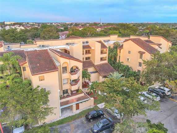 Aerial view of a residential apartment complex with multiple buildings and parking area.