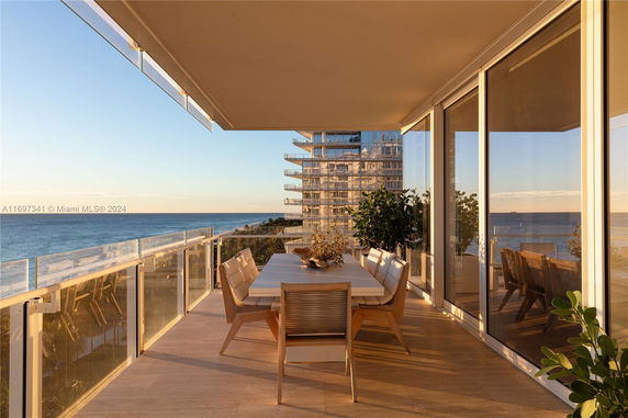Outdoor terrace with dining furniture overlooking the ocean.