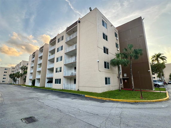 Front view of a multi-story apartment building with balconies.