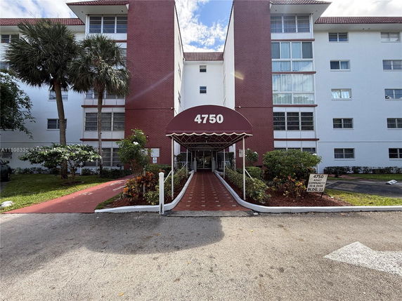 Front view of a multi-story residential building with a central entrance covered by an awning labeled '4750'.