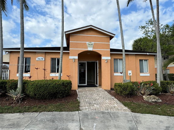Front view of a single-story building with an arched entrance and orange exterior.