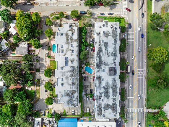 Aerial view of two parallel multi-story buildings with a central swimming pool and surrounding roads.
