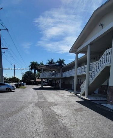 Front view of a two-story building with a staircase and balcony.