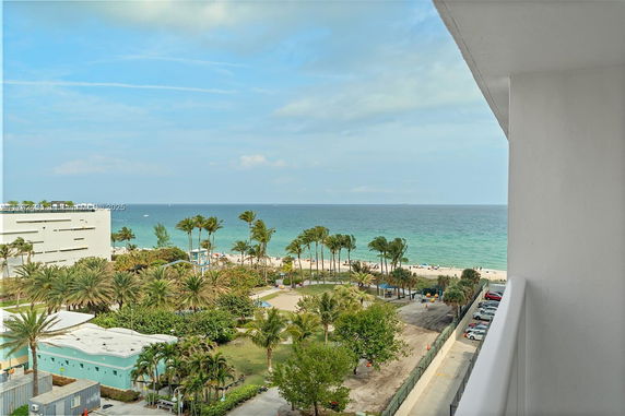 Panoramic view of a beach and ocean from a building balcony.