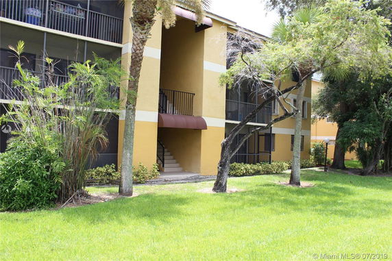 Front view of a multi-story building with balconies and staircase.