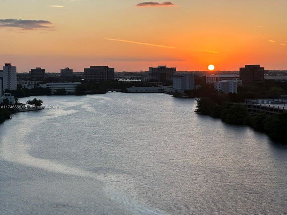 Panoramic view of a river with buildings in the background during sunset.
