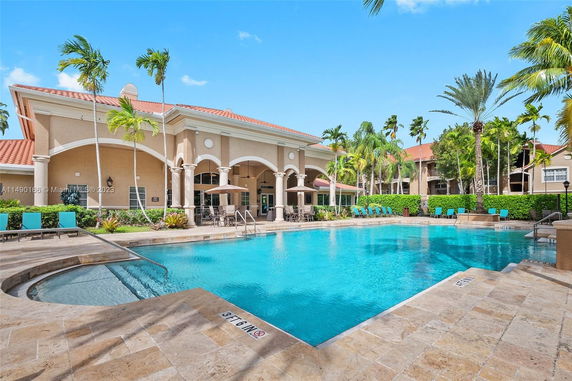Outdoor swimming pool area with a building in the background.