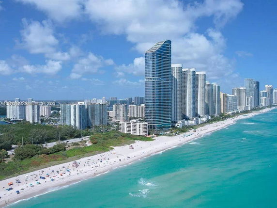 Panoramic view of beachfront high-rise buildings next to the ocean.