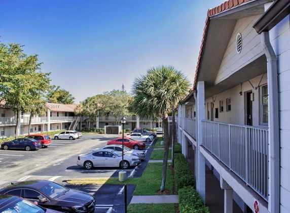 View of a parking area adjacent to a multi-story residential building.
