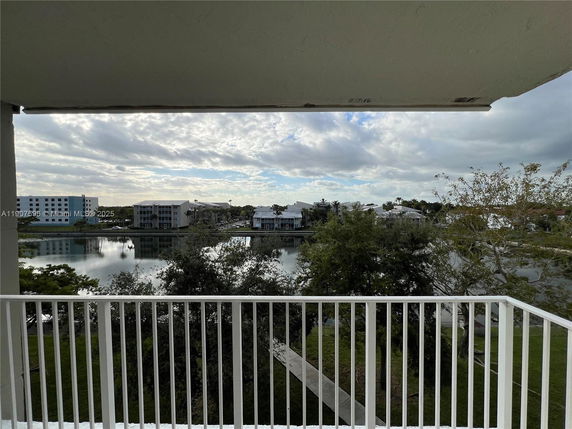 View from a balcony overlooking a water body and distant buildings.