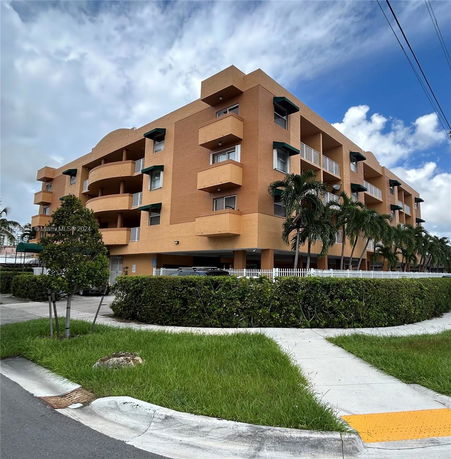 Front view of a multi-story residential building with balconies and a light brown facade.