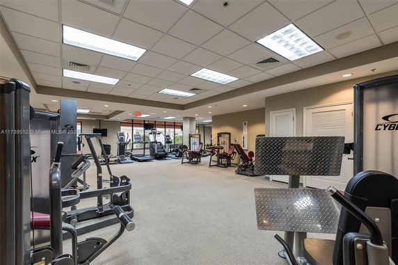 Fitness gym room with exercise equipment and machines.
